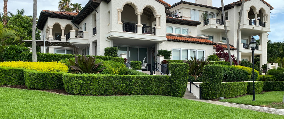A scenic landscape view featuring a meticulously manicured green lawn in the foreground, backed by beautifully trimmed